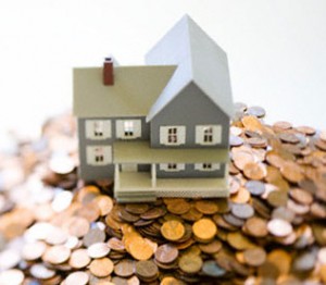 Model House Sitting on Pile of Pennies