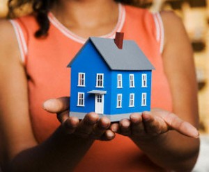 woman holds tiny house