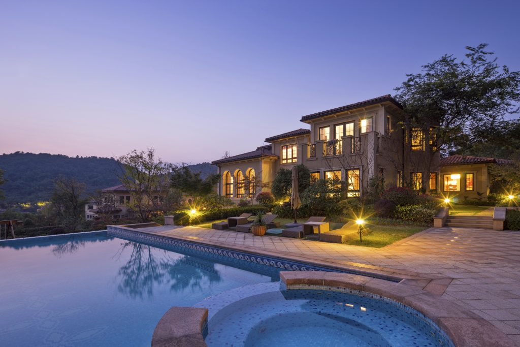 night scene of modern waterfront villa with meadow outdoors and illuminated sky