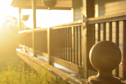Afternoon rays of sun against a wooden porch