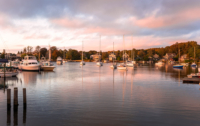 Beautiful natural harbour with anchored sailboats at sunset in autumn. Falmouth, Cape Cod, MA, USA.