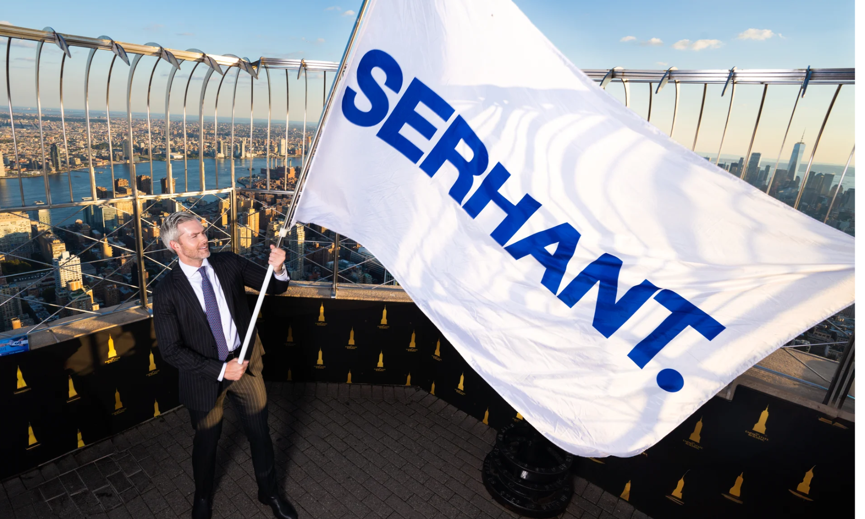 SERHANT. CEO waves a flag that says "SERHANT."